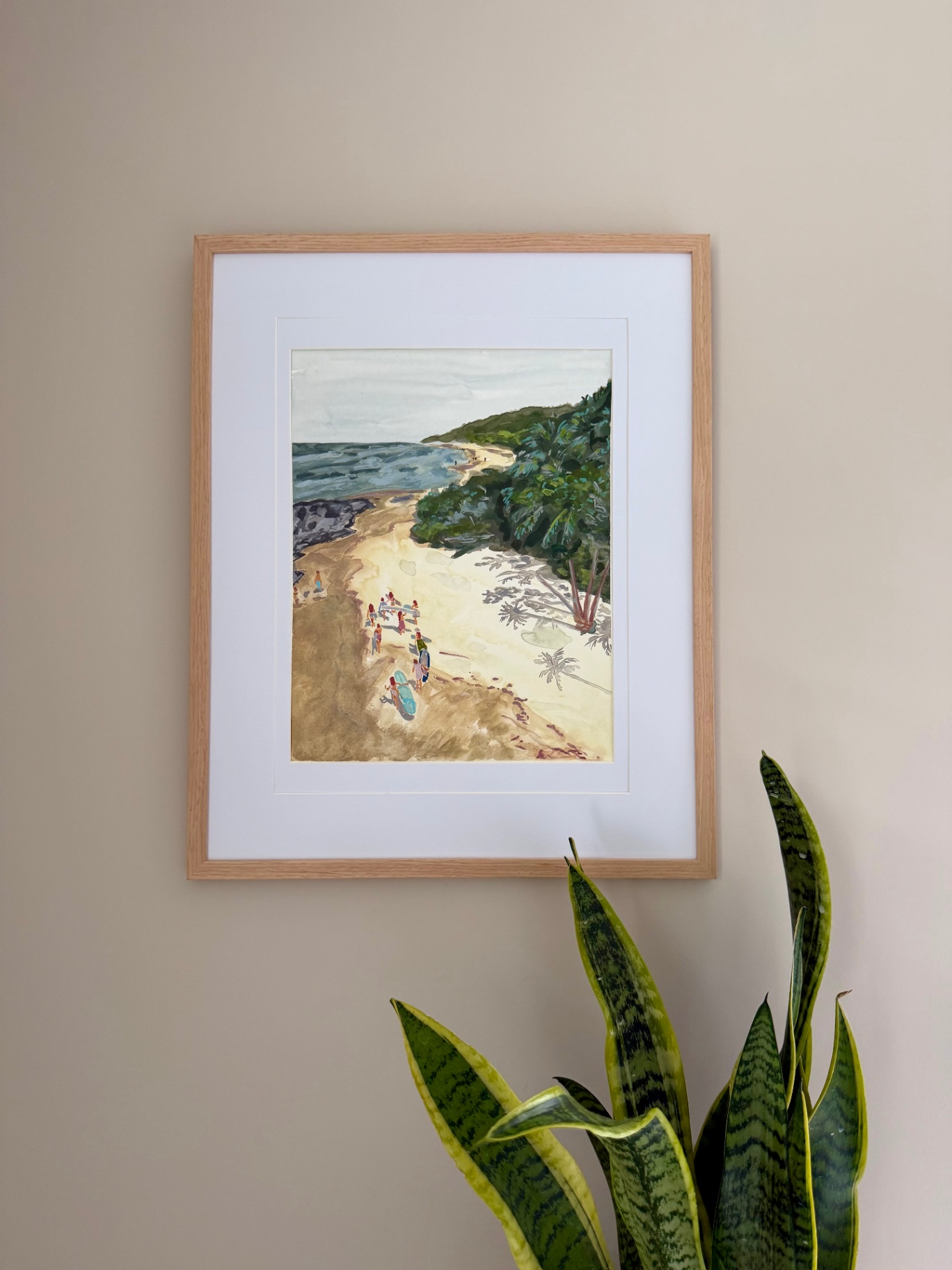 Framed watercolor of surfers gathering on a quiet cove beside a palm-covered hillside