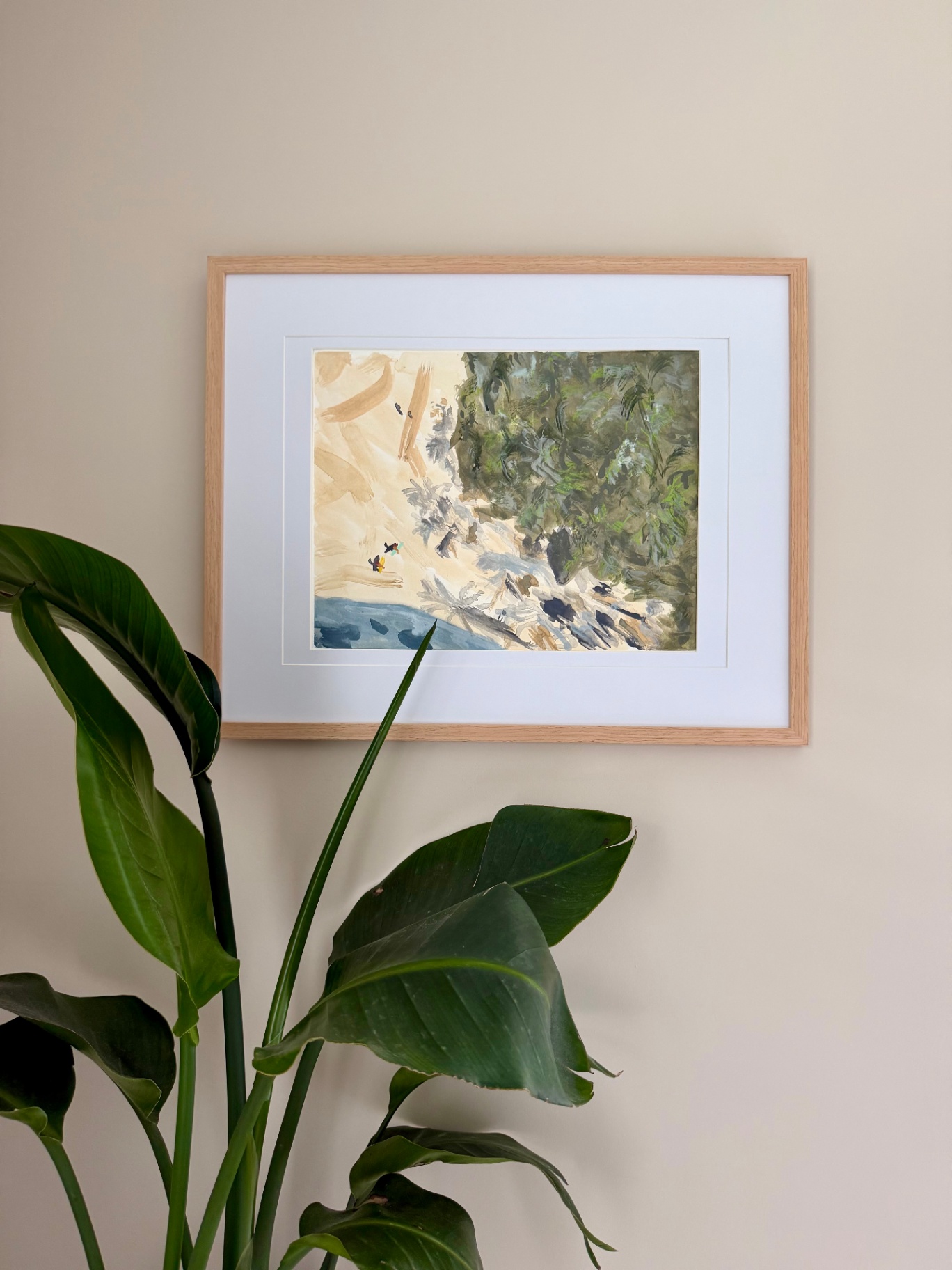 Framed watercolor of a sandy shoreline meeting dense jungle greenery