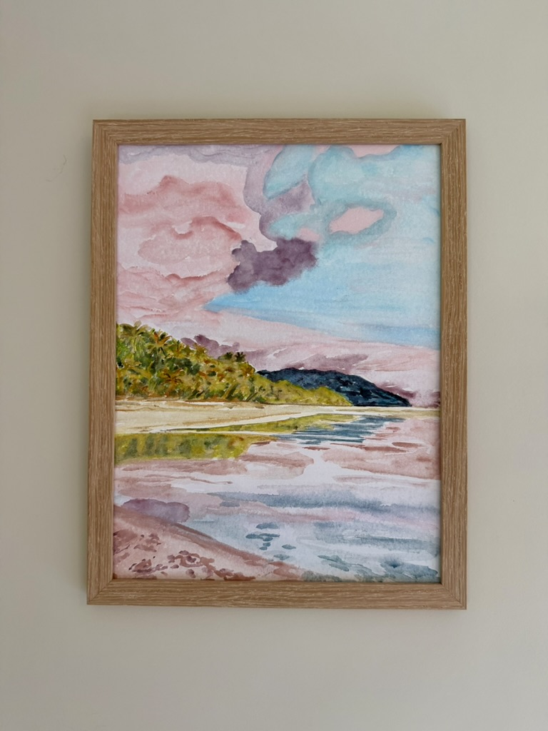 Framed watercolor of a coastal lagoon at sunset with pink clouds reflecting on still water