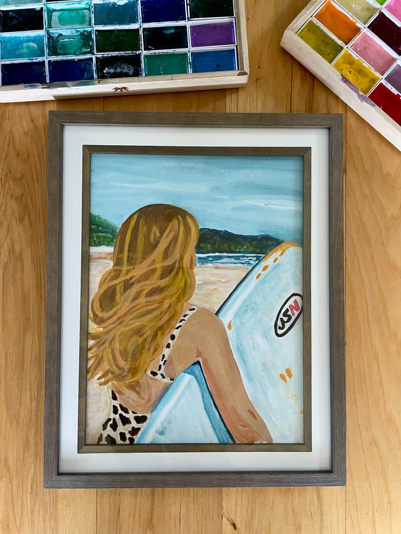 Watercolor of a long-haired surfer resting with her board on a Costa Rican beach