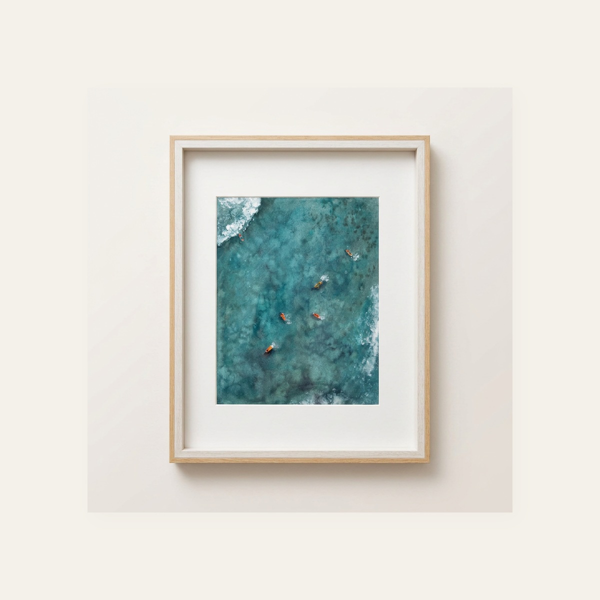 Framed aerial watercolor of surfers waiting in teal green water