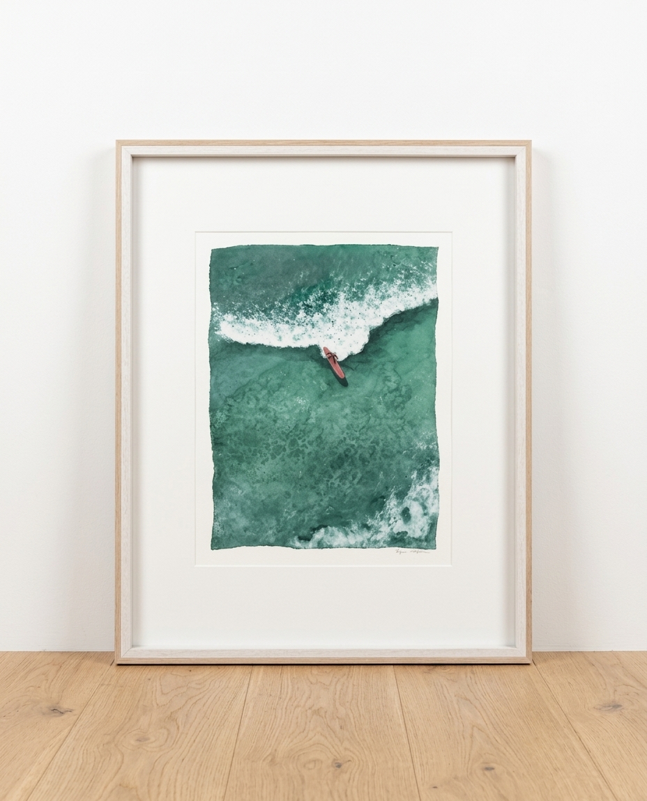 Framed aerial watercolor of a lone surfer paddling beside a breaking wave in deep green water