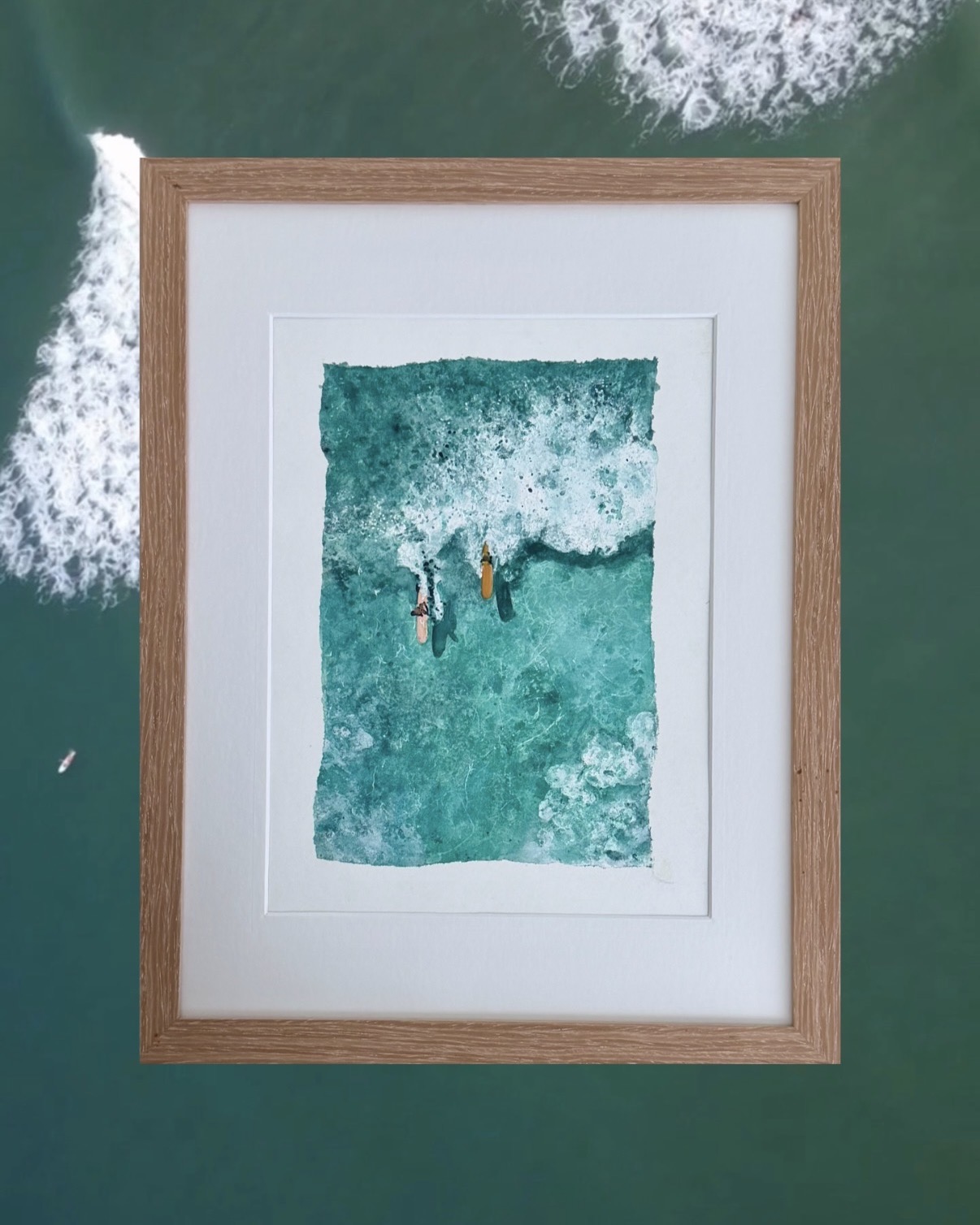 Framed aerial watercolor of two surfers paddling in turquoise water